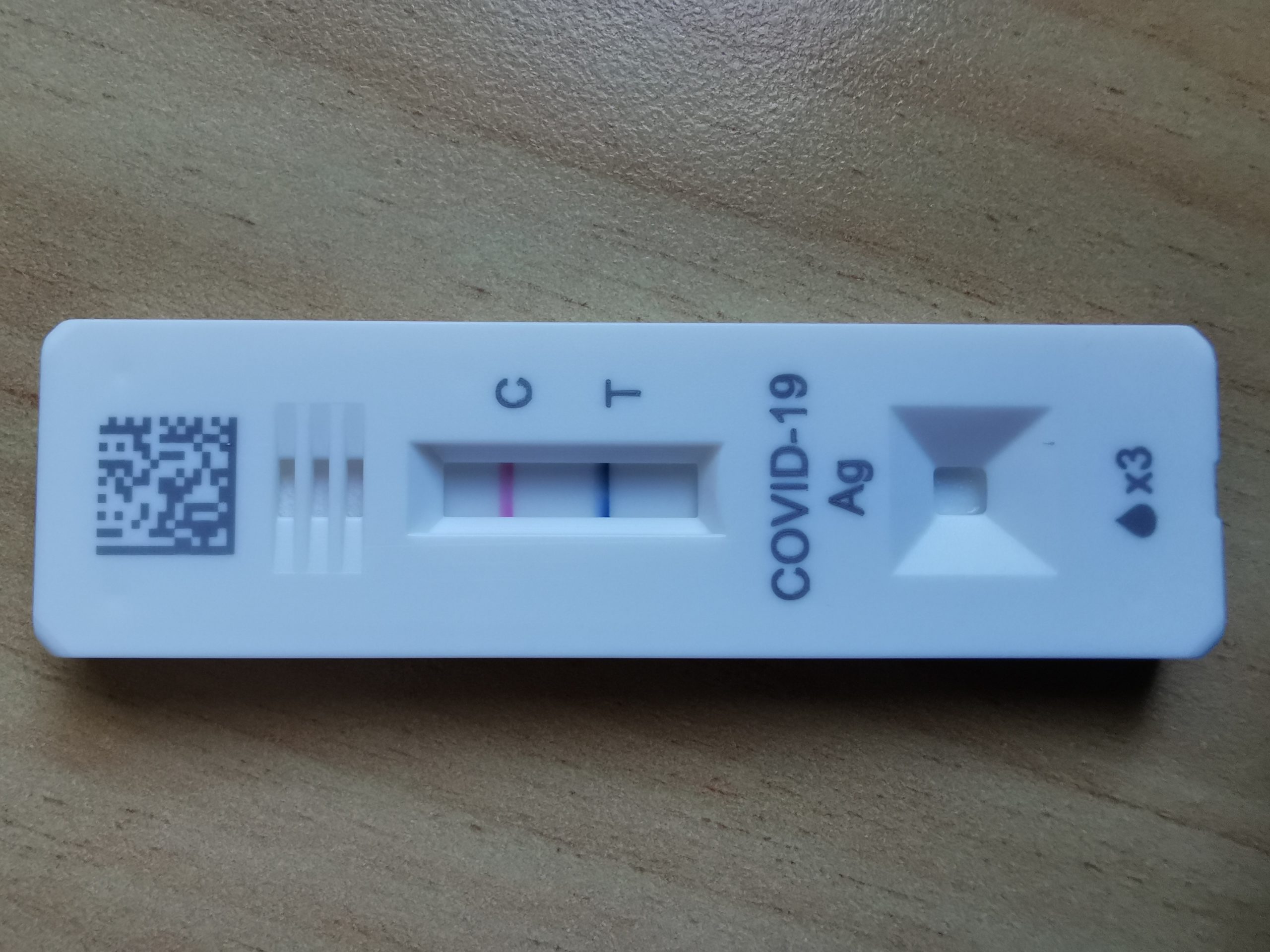 Rapid Antigen Test Cassette with both the Control and Test lines visible indicated a COVID positive result